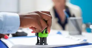 Hand stamping approval on a document, representing FDA drug approvals granted in July 2026