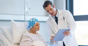 Oncologist reviewing OGSIVEO nirogacestat treatment data on a tablet with a desmoid tumor patient in a hospital room