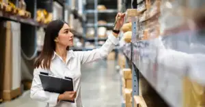 Clinical trial supply professional reviewing pharmaceutical inventory in a warehouse
